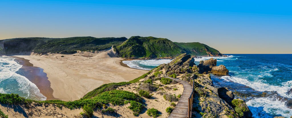 The stunning point of Robberg Peninsula, where vibrant turquoise waters flank both sides of the land, creating an island-like vista, Plettenberg Bay, South Africa